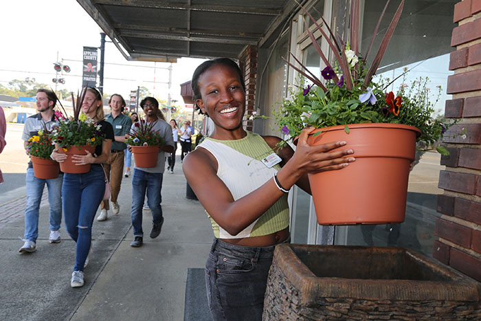 Linet Namuli, a third-year economics major from Kampala, Uganda, helps place planters in downtown Baxley as part of the PROPEL Rural Scholars program. 