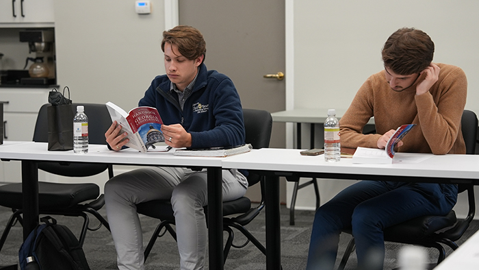 From left, Christian Dent and Hendley Jones peruse the Handbook for Georgia Legislators during a session preparing them for the 2024 Georgia Legislative Internship program. (Photo by Sara Ingram, UGA)