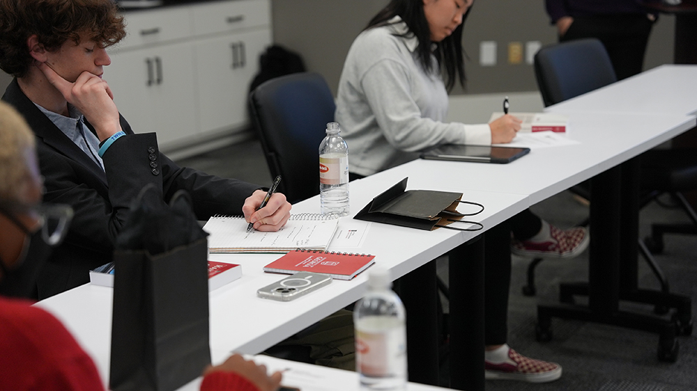 Clockwise from bottom left, Yannceley Armand, Jackson Cliett and Shania Nguyen-Tu take notes during orientation for the 2024 Georgia Legislative Internship Program. They are among seven University of Georgia undergrads selected as GLIP interns for the 2024 spring semester. (Photo by Sara Ingram, UGA)