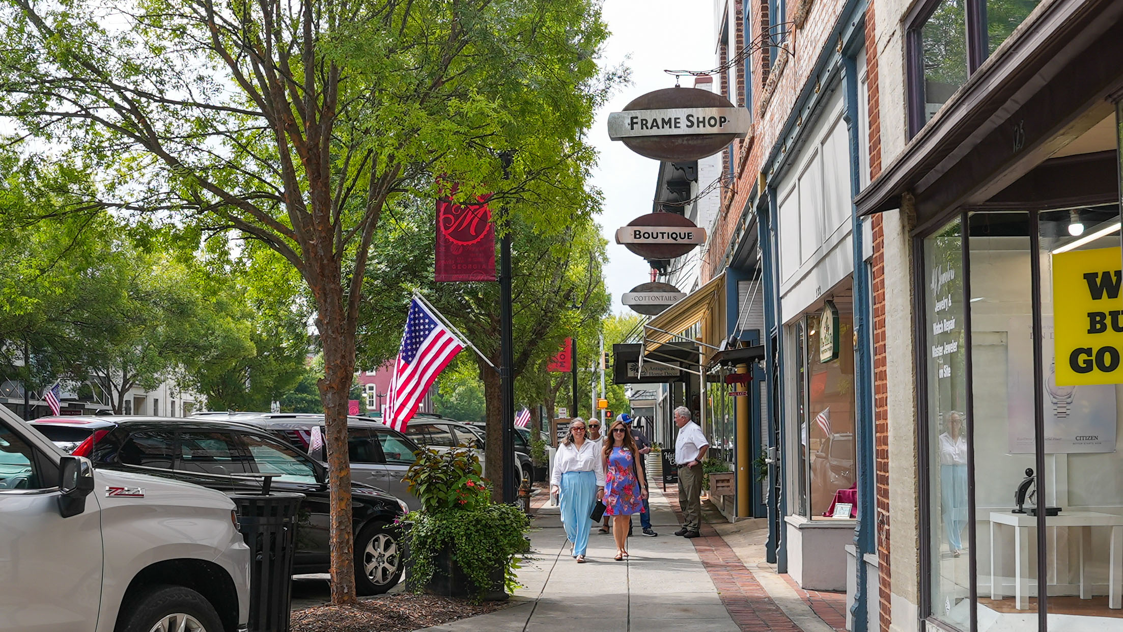 A photo of people walking along a sidewalk in Monroe, GA