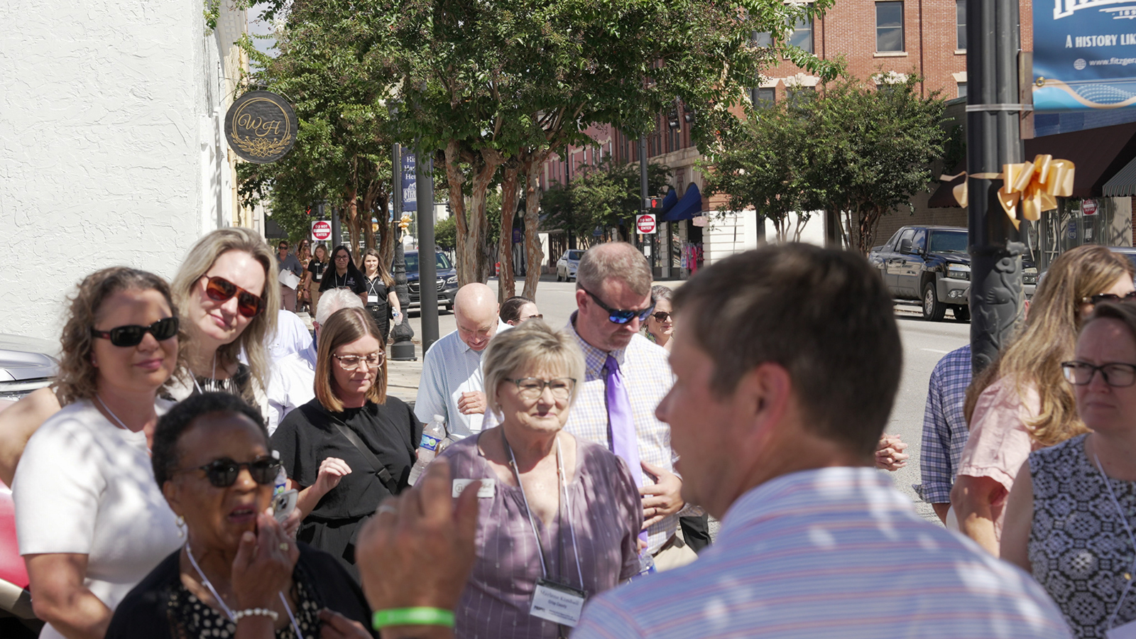 PROPEL Ramble attendees stand bon sidewalk listening to Jason Dunn