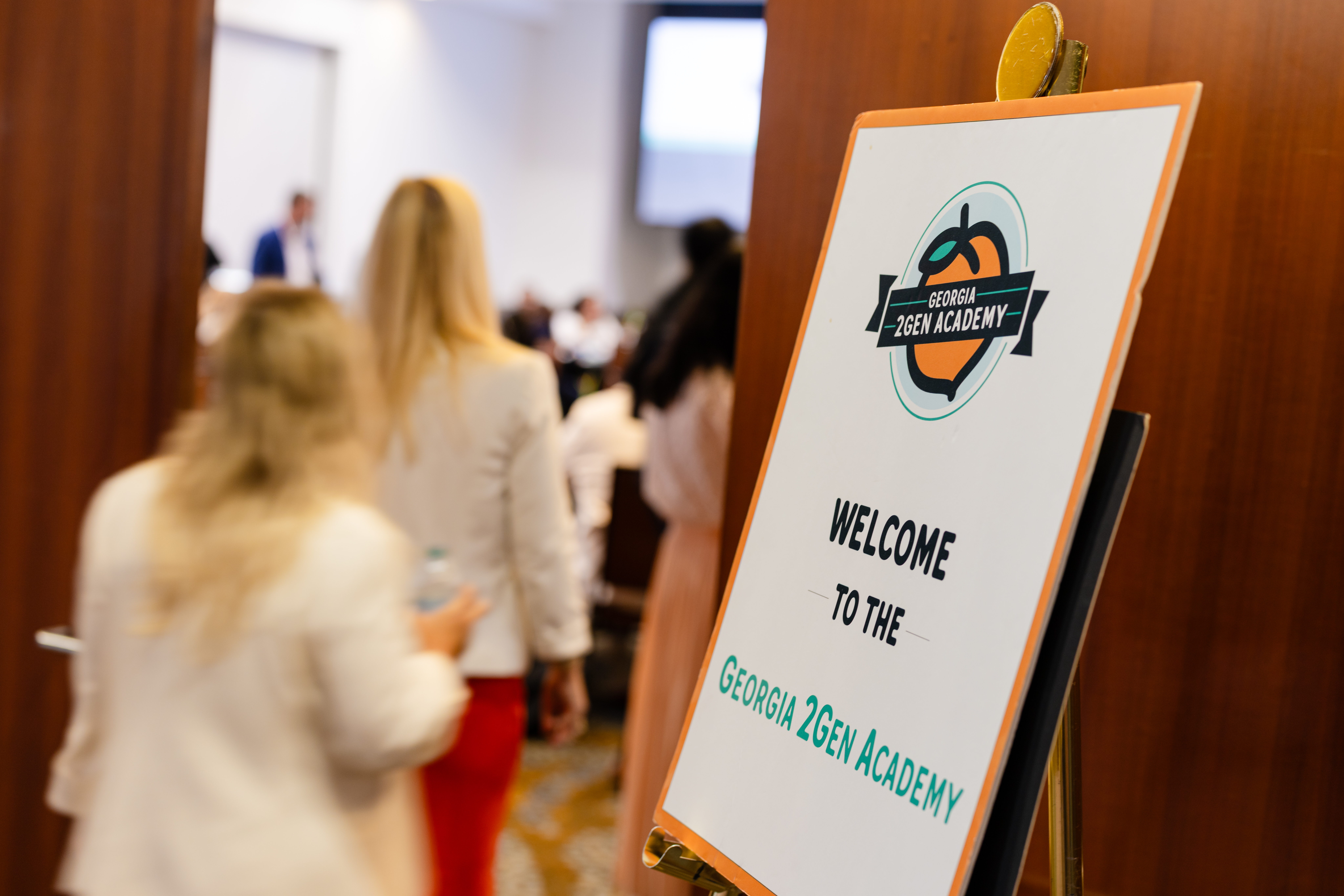 People walk past a welcome sign at the Georgia 2Gen Academy graduation celebration. Photo by Casey Sykes.