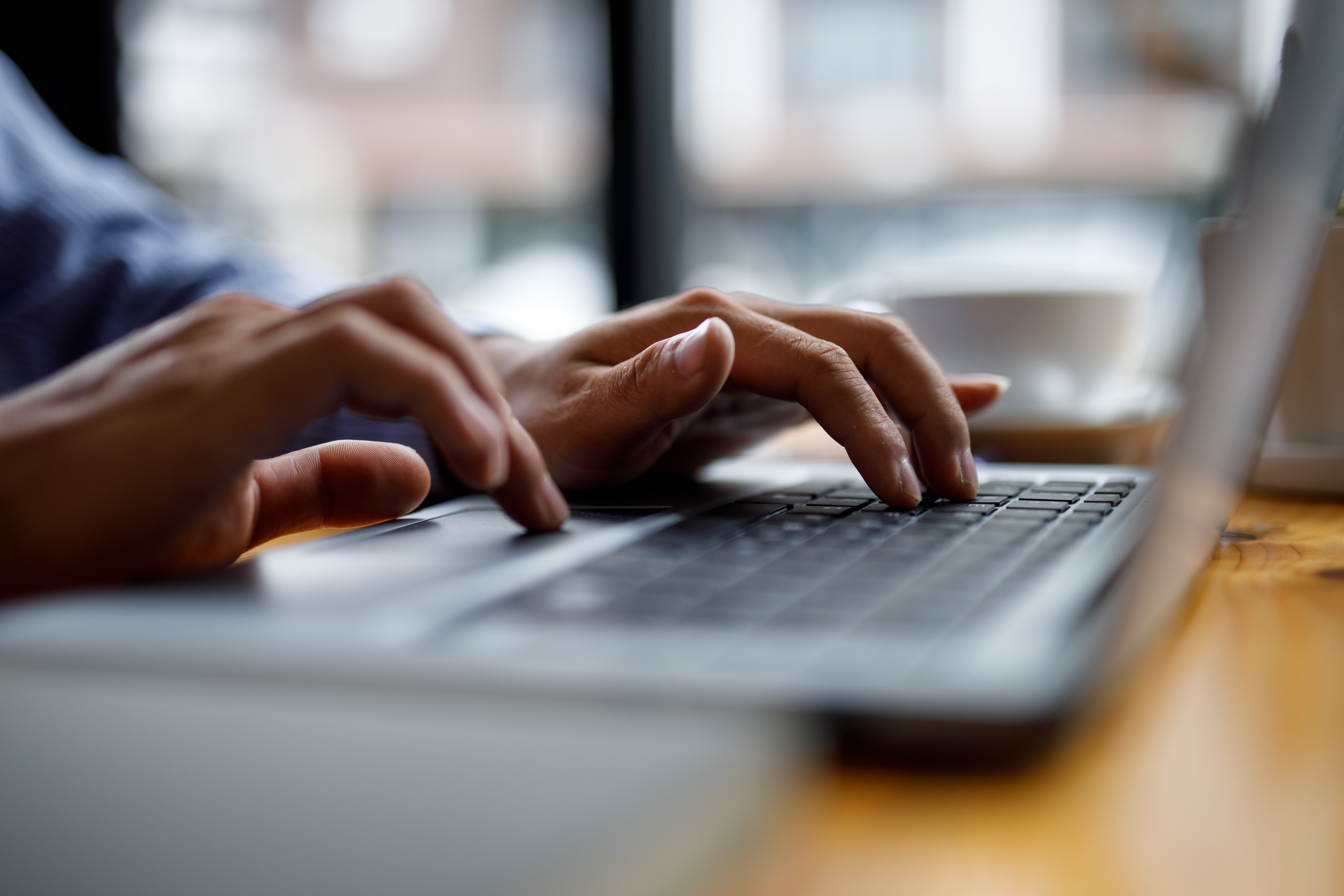 Stock image of hands resting on a computer