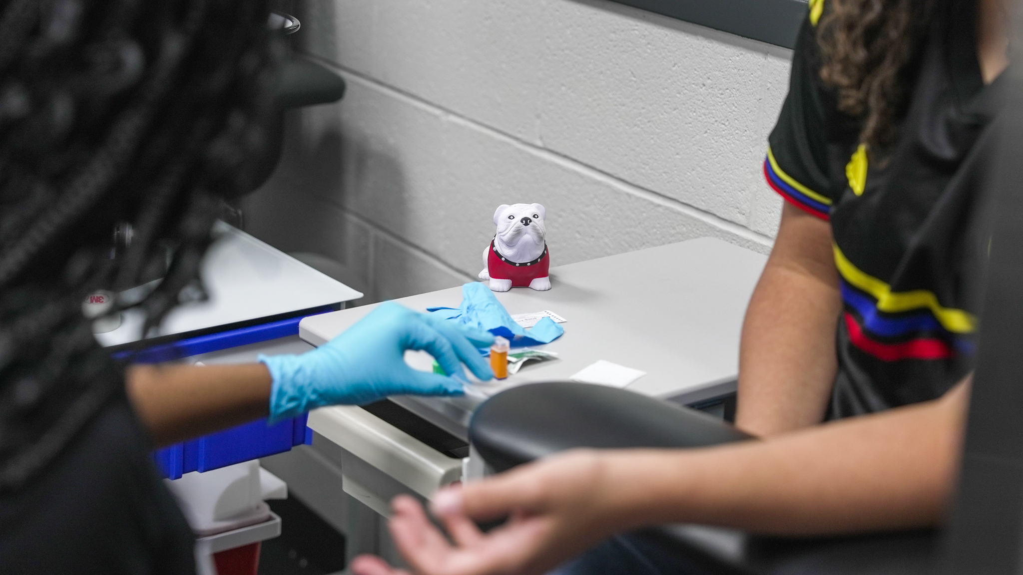 Students practice finger sticks in a phlebotomy class.