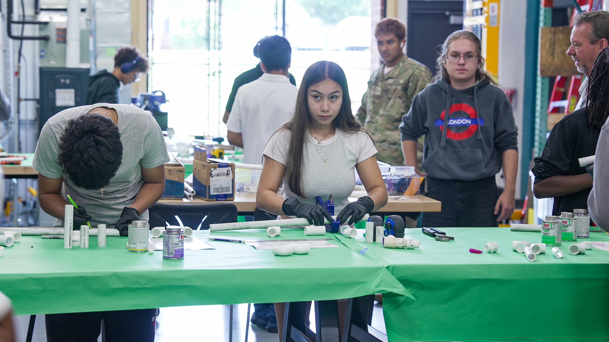 Students practice cutting and joining PVC pipe by building marshmallow launchers in the HVAC classroom.