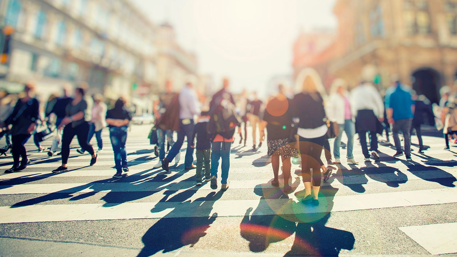 crowd of people going across a road